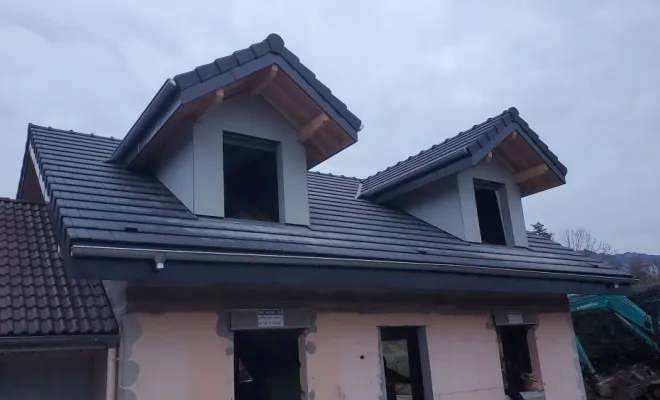 Reconstruction d'une toiture complète avec charpente en bois, jacobines, velux et couverture en terre cuite à Tresserve (Savoie - 73)